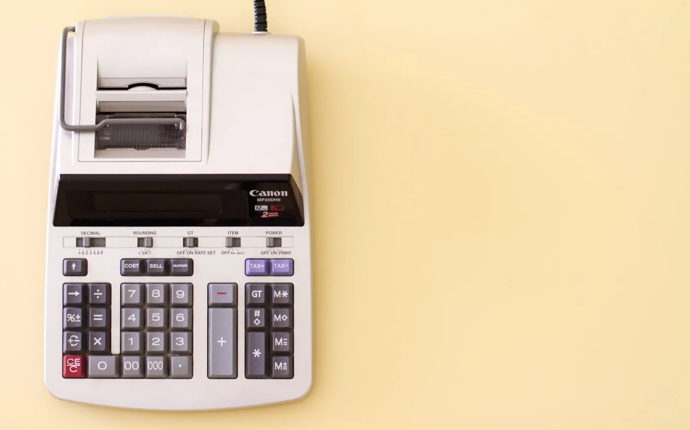 Ten key accounting calculator on a soft yellow desk