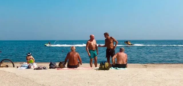 3 women and 2 men sitting on beach sand during daytime by Elena Rabkina courtesy of Unsplash.